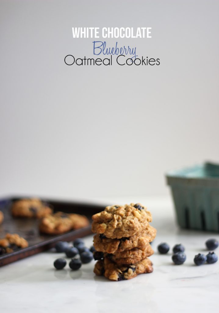 small stack of blueberry oatmeal cookies in front of a baking sheet.