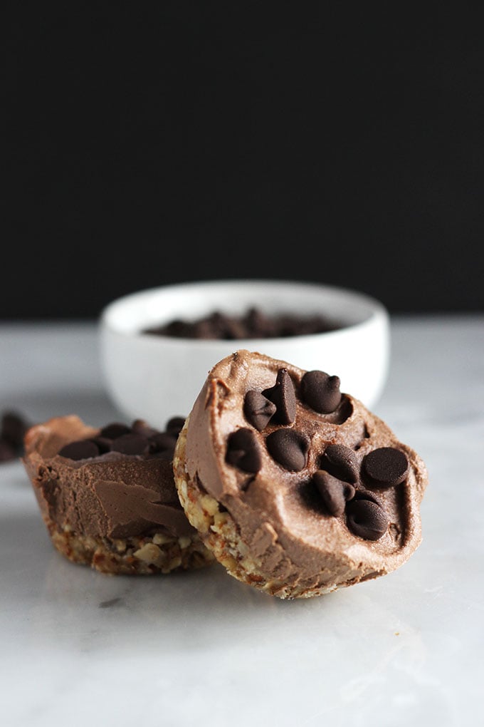 Vegan Mocha Cheesecakes topped with chocolate chips on a white table.