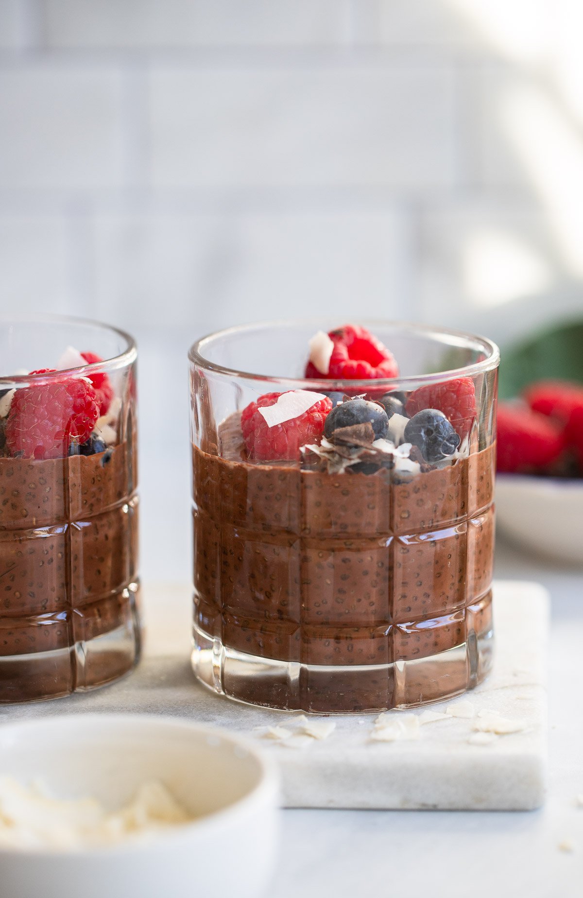 chocolate chia seed pudding in a glass garnished with fresh berries.