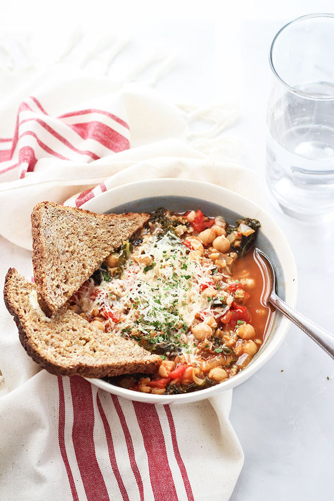 Italian Farro soup in a bowl topped with grated parmesan. 