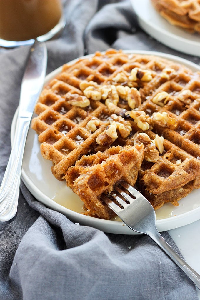 Vegan Carrot Cake Waffles topped with walnuts on a white plate.