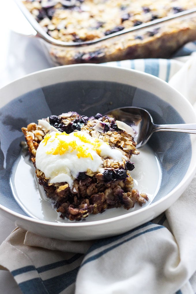 Vegan Lemon Blueberry Baked Oatmeal served in a bowl with yogurt on top.