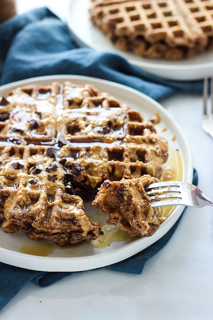 Vegan Chocolate Peanut Butter Waffles topped with chopped chocolate and syrup.