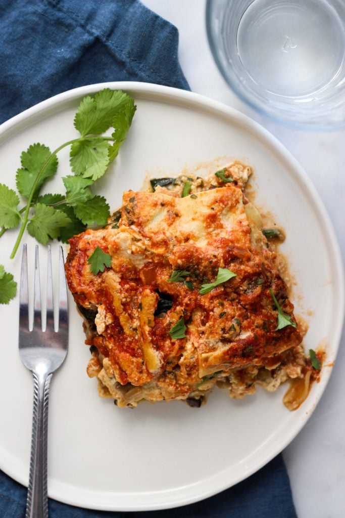 Vegan Lasagna with tofu ricotta on white plate with fork