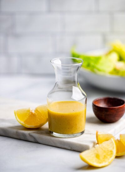 lemon dijon salad dressing in a small glass pitcher.