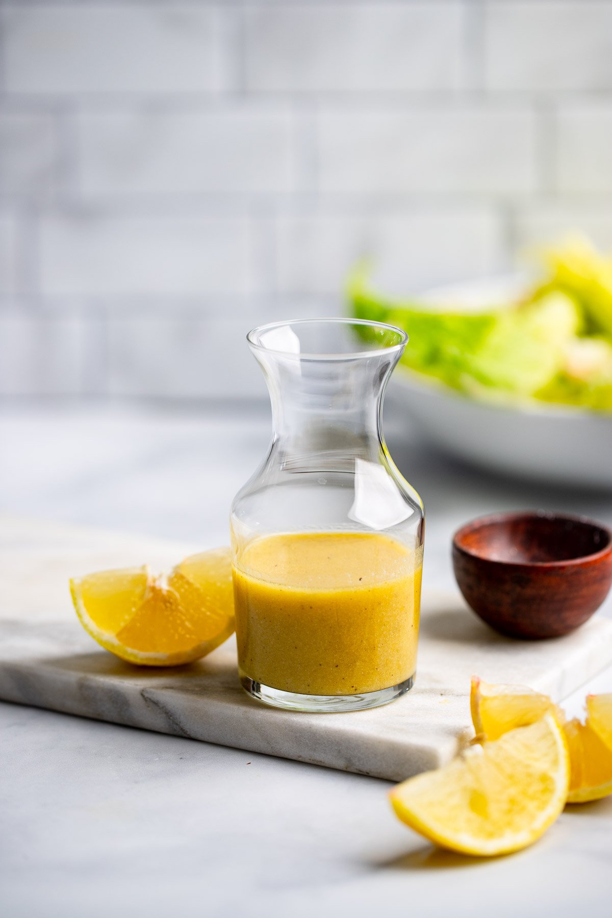 lemon dijon salad dressing in a small glass pitcher.