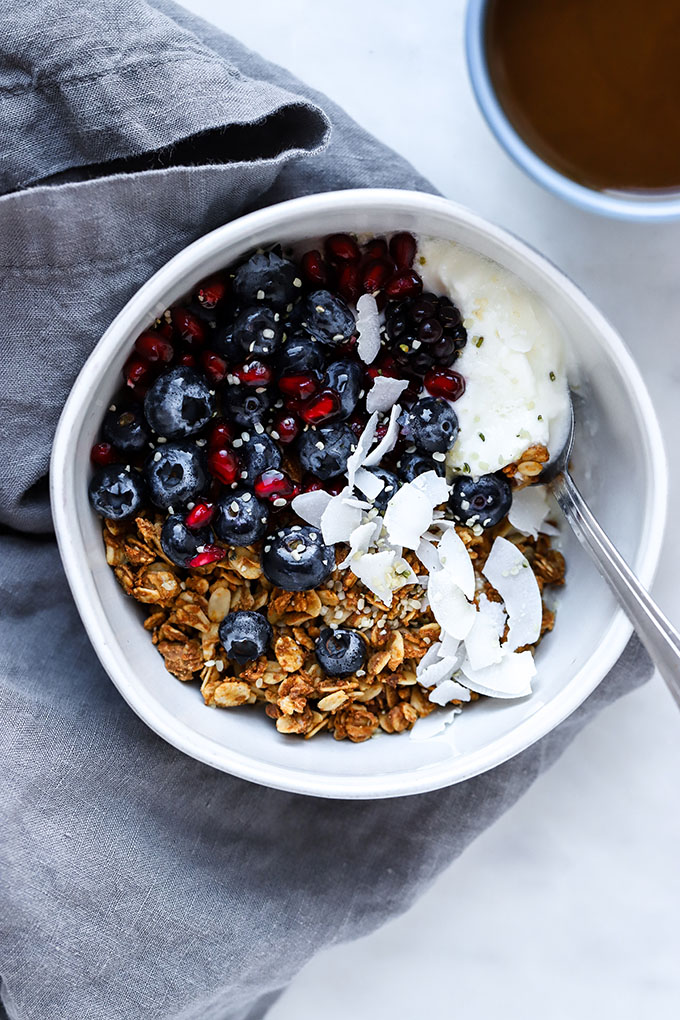 Healthy Peanut Butter Granola in a white bowl with berries and yogurt