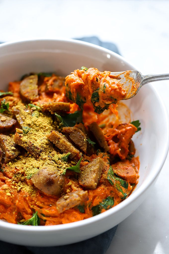 spaghetti squash with romesco sauce in white bowl