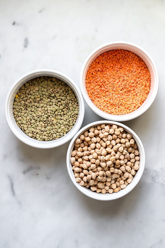 Lentils and chickpeas in white bowls.