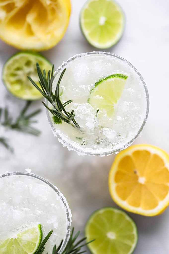 rosemary margarita in glass garnished with lime and rosemary.