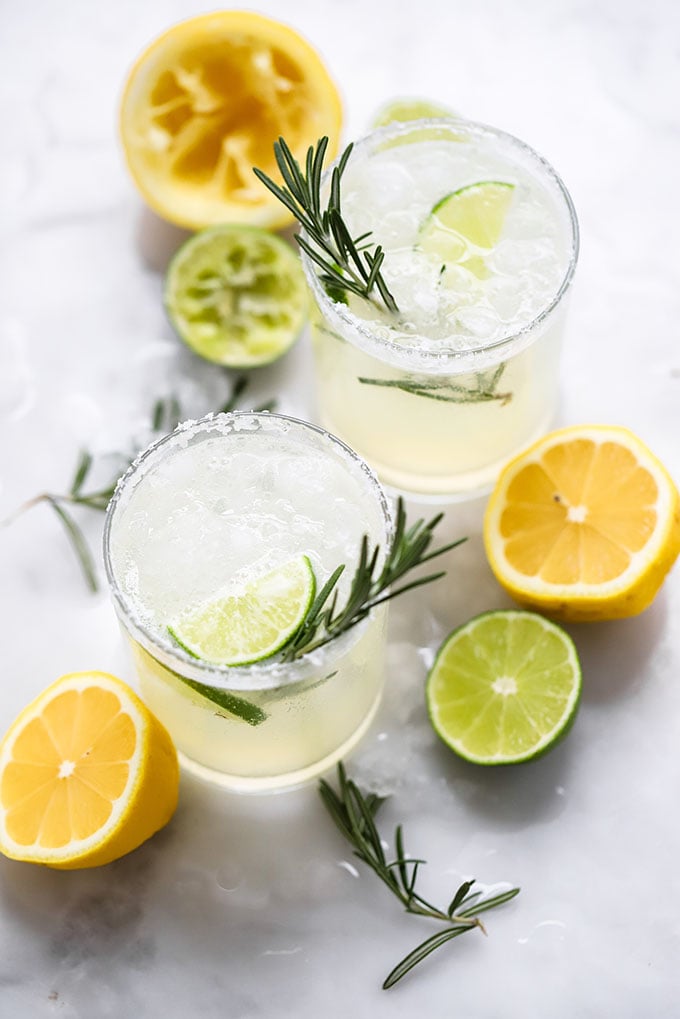simple rosemary margarita in glass garnished with fresh rosemary and lime. 