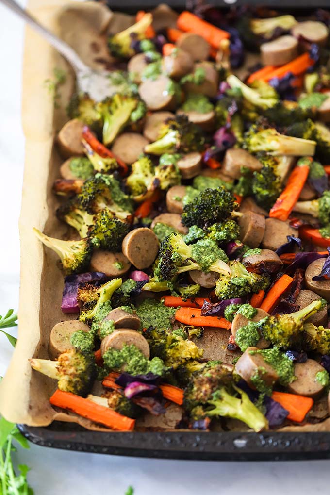 sheet pan veggies, sausage, and pesto on a baking sheet. 