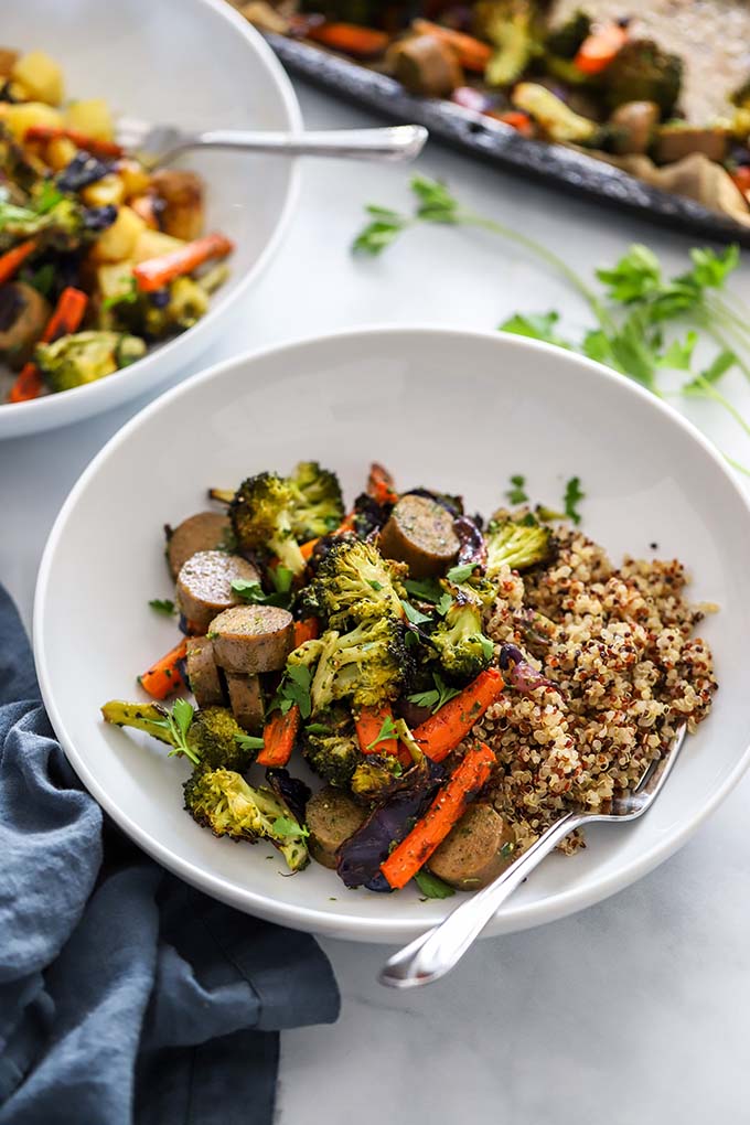 vegan sheet pan sausage and veggies in a serving bowl with quinoa. 