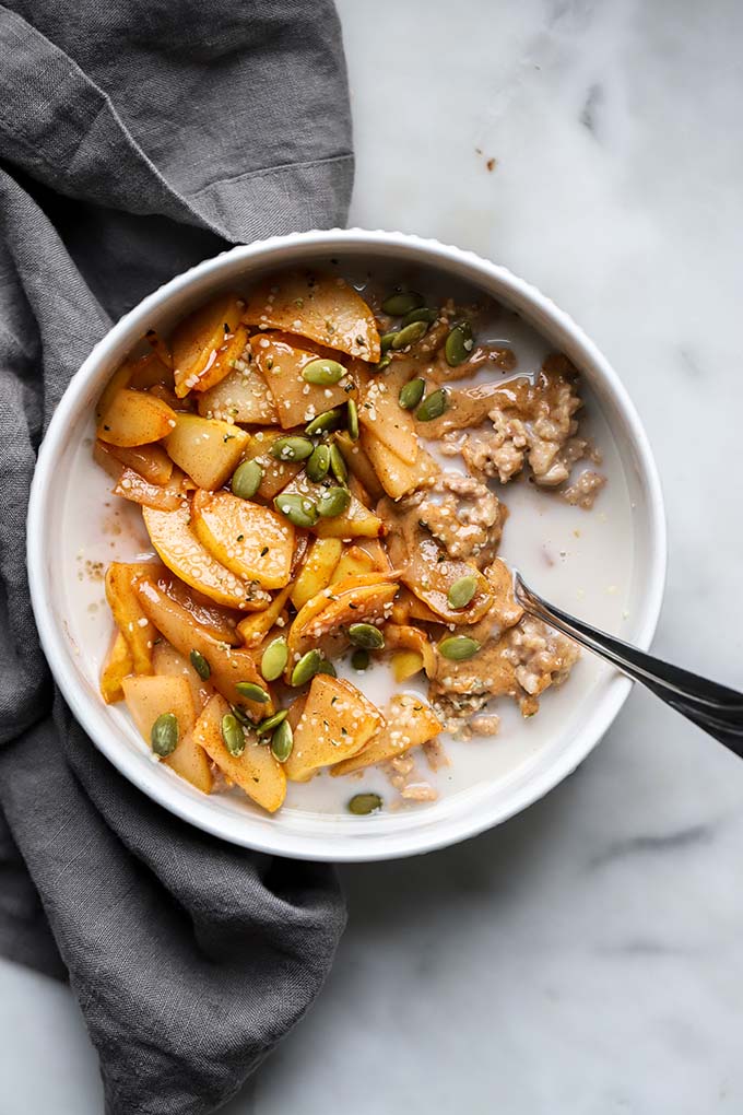 Oatmeal topped with sautéed cinnamon pears with gray napkin