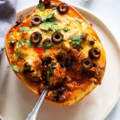 vegetarian enchilada spaghetti squash on white plate with fork