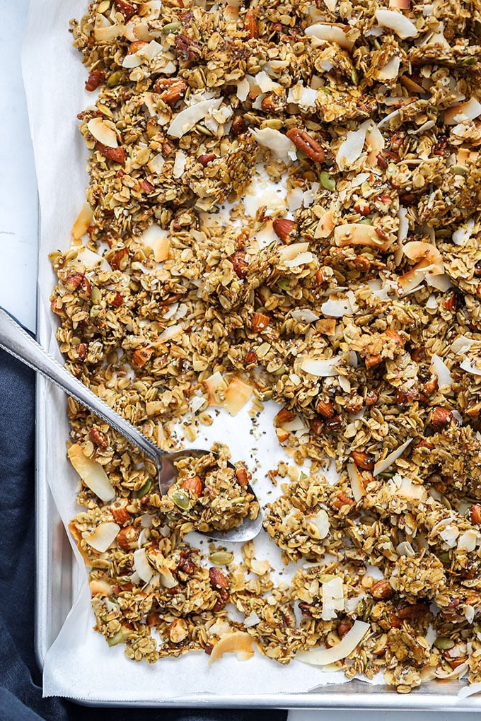 healthy super seedy granola on sheet pan with spoon