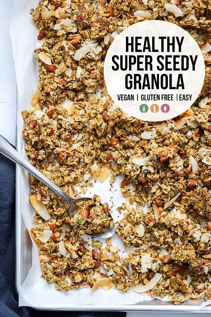 healthy super seedy granola on sheet pan with spoon and text