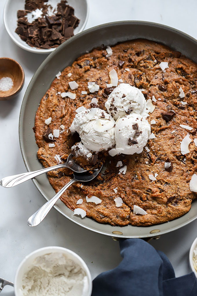 peanut butter chocolate chip skillet cookie with ice cream and 2 spoons