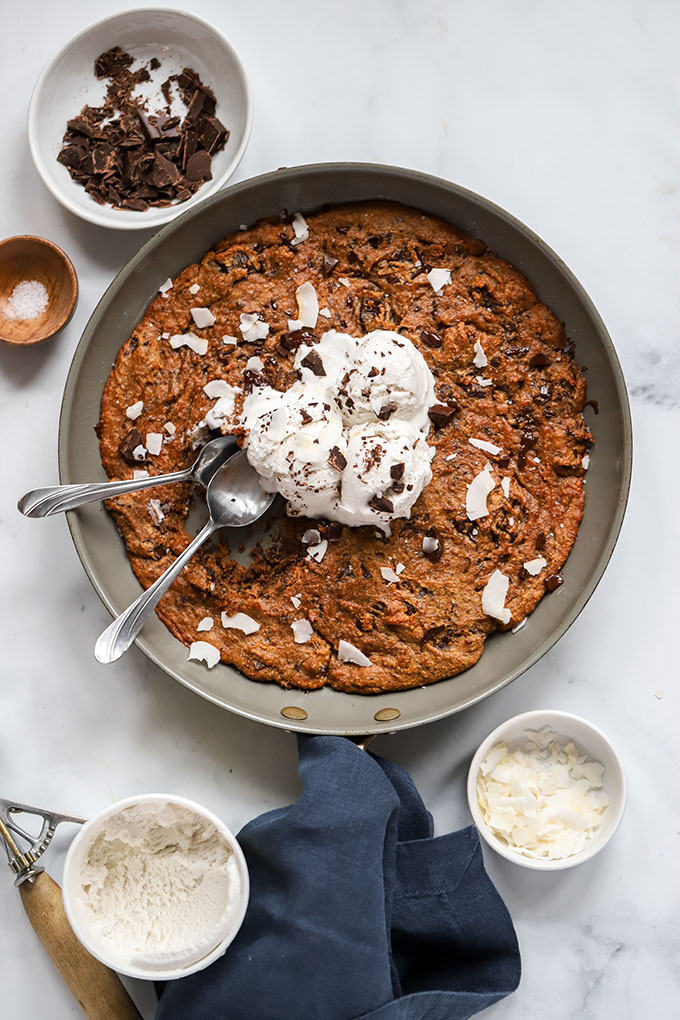 peanut butter chocolate chip skillet cookie with ice cream and 2 spoons