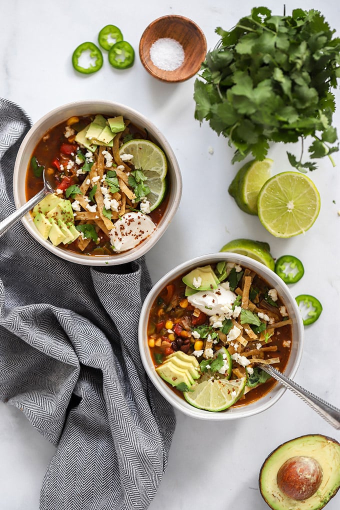 Two bowls of vegan tortilla soup with napkin