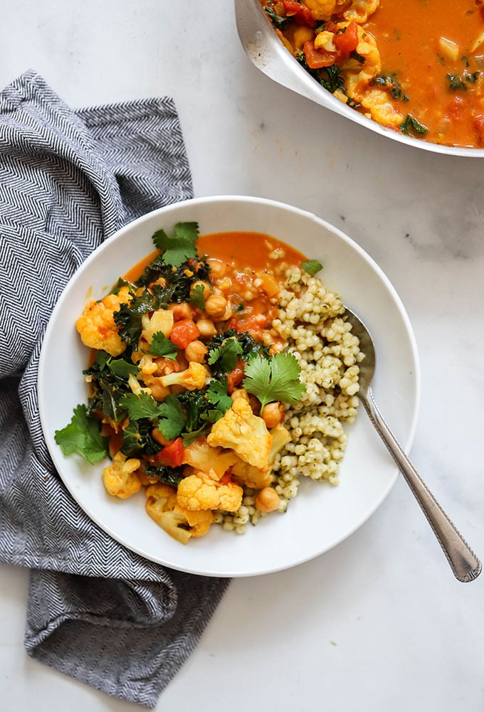 healthy one pot cauliflower stew with curry in bowl with couscous.