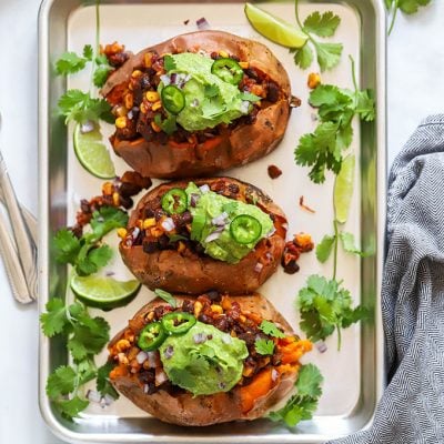 3 vegan loaded sweet potatoes on tray