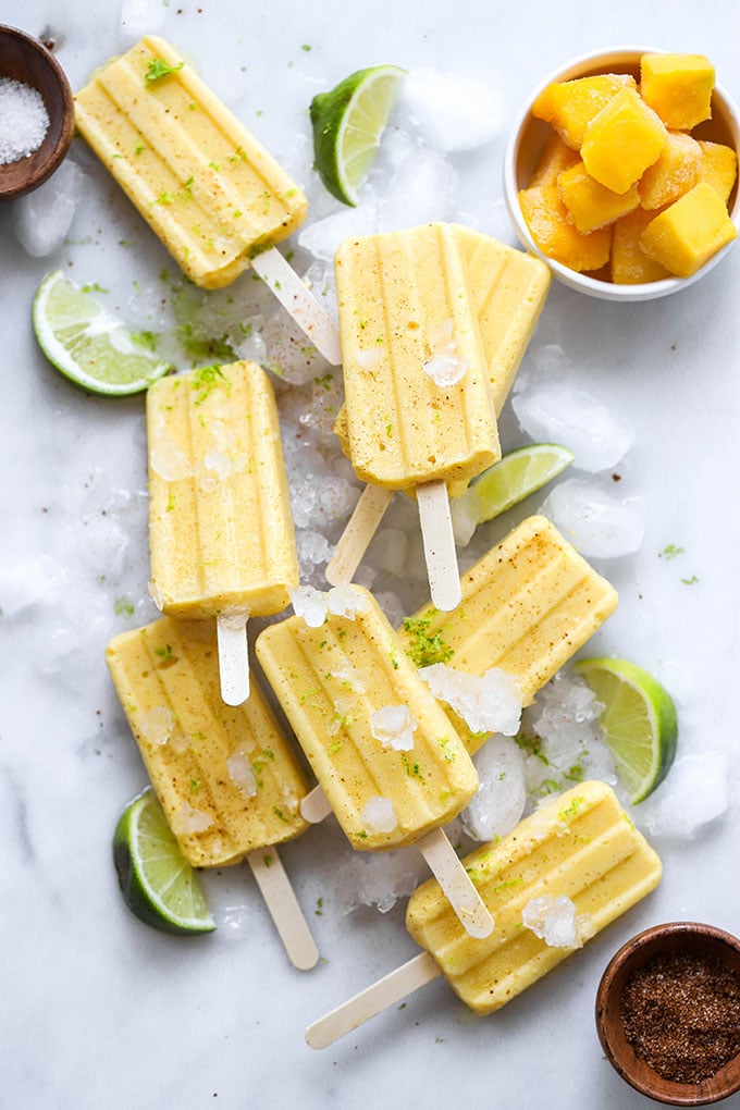 vegan mango lime popsicles on white marble background