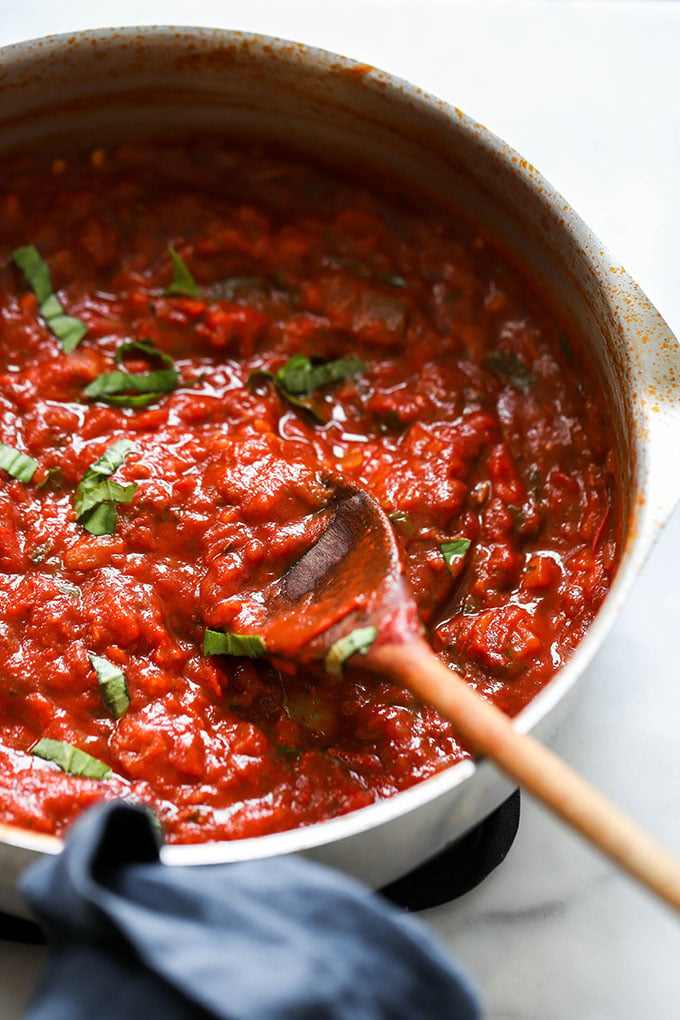 close up of tomato sauce in skillet with basil.