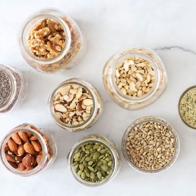 nuts and seeds in jars on marble background