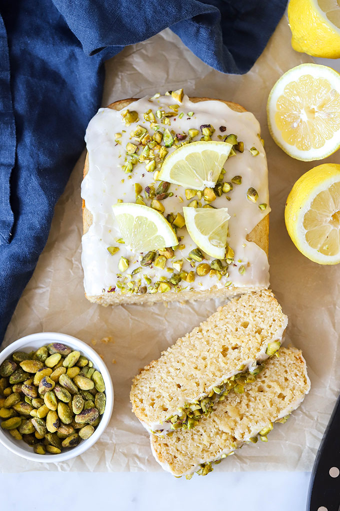 vegan lemon loaf with pistachios and lemon wedges