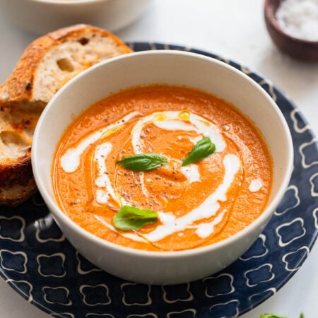 roasted tomato basil soup in a bowl garnished with fresh basil.