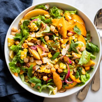 Summer peach salad with chickpeas, almonds, corn, and red onion