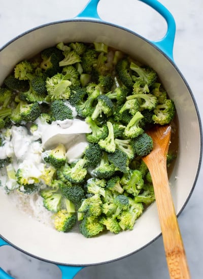 dutch oven with broccoli, broth, and coconut milk before cooking. 