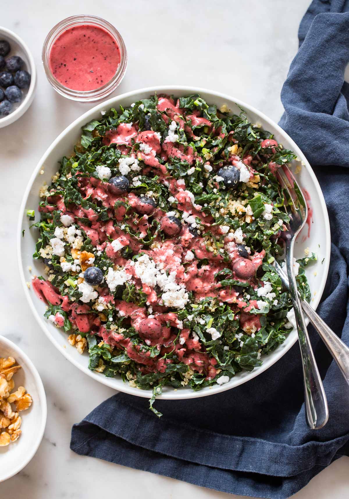 Blueberry Kale Summer Salad in white bowl with serving fork