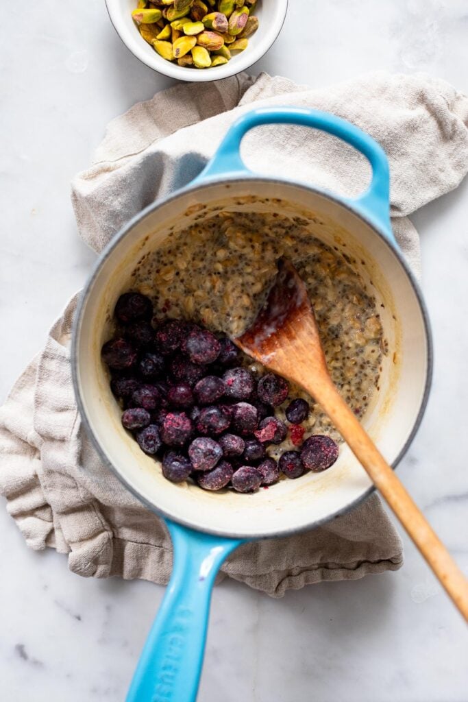 cooked oatmeal in saucepan with blueberries