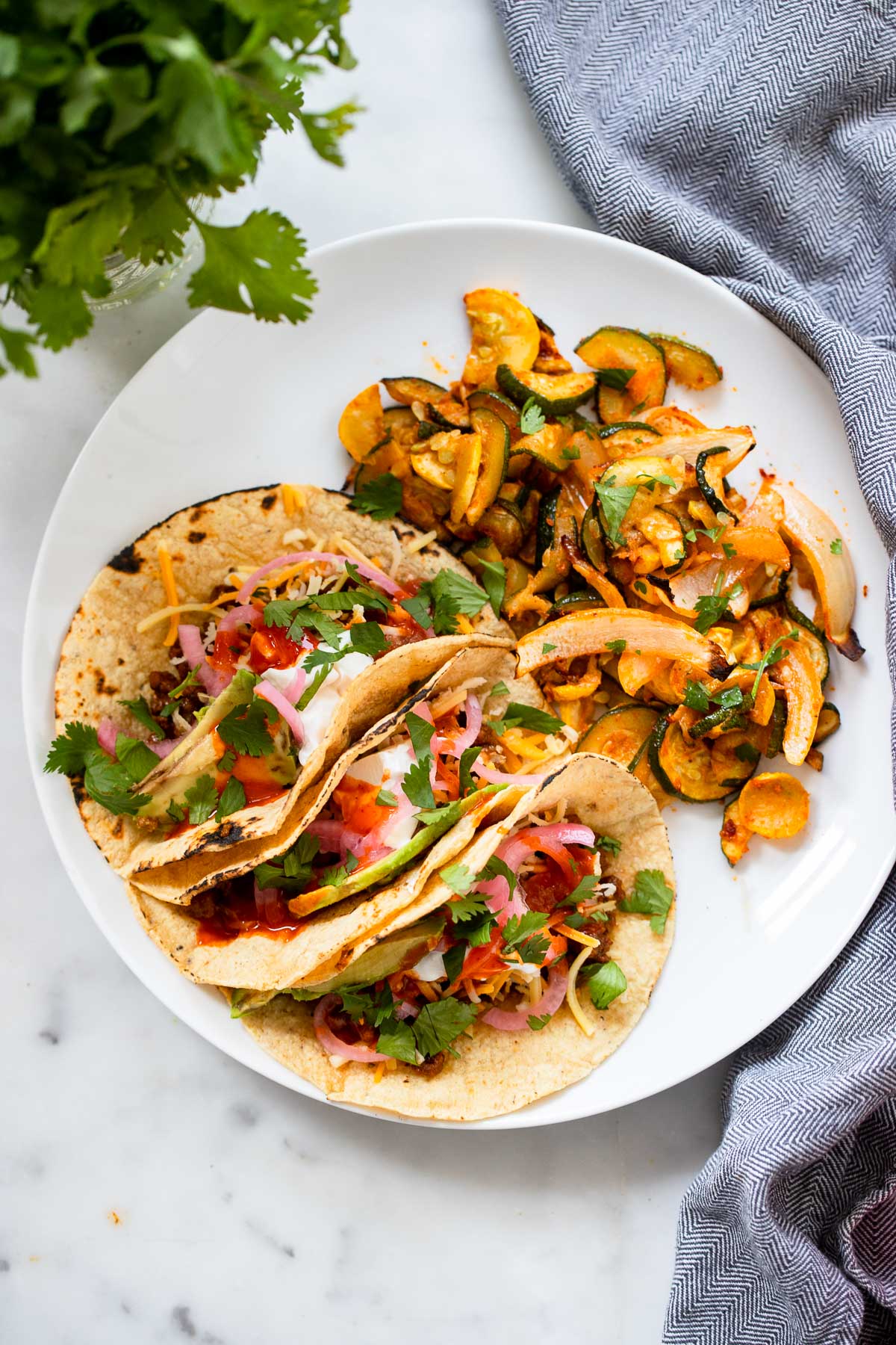 easy vegan tacos with seitan on plate with cooked zucchini.