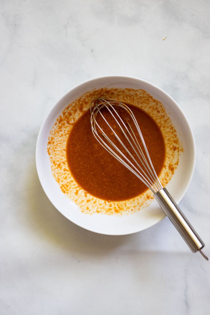 vegan lettuce wrap sauce in bowl with whisk.