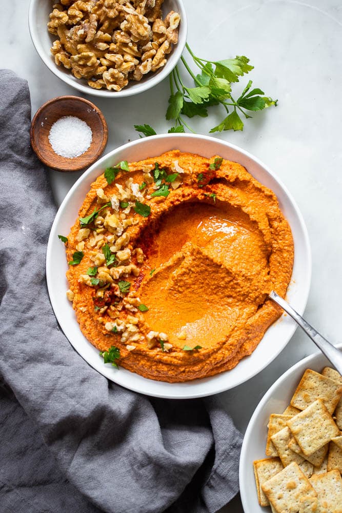 roasted red pepper dip in bowl garnished with chopped walnuts.