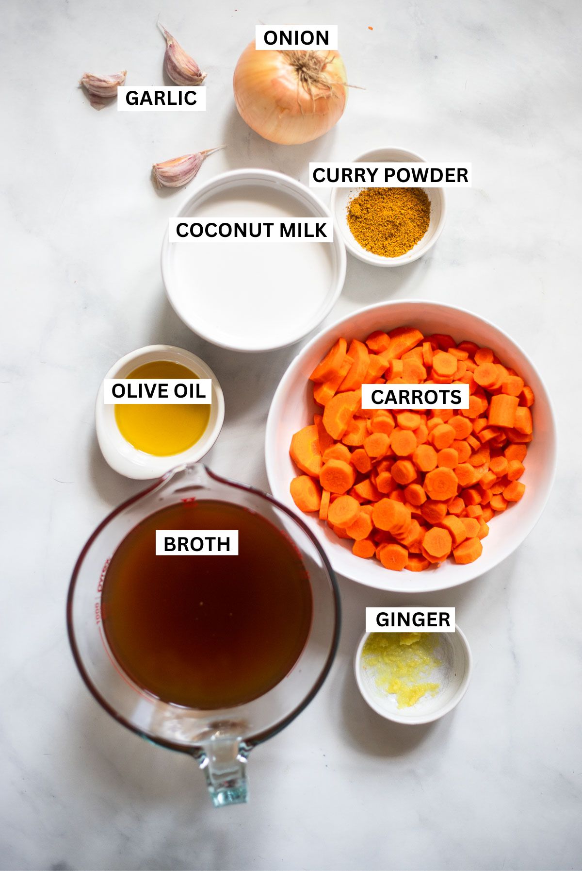 creamy carrot soup ingredients in various bowls with labels. 