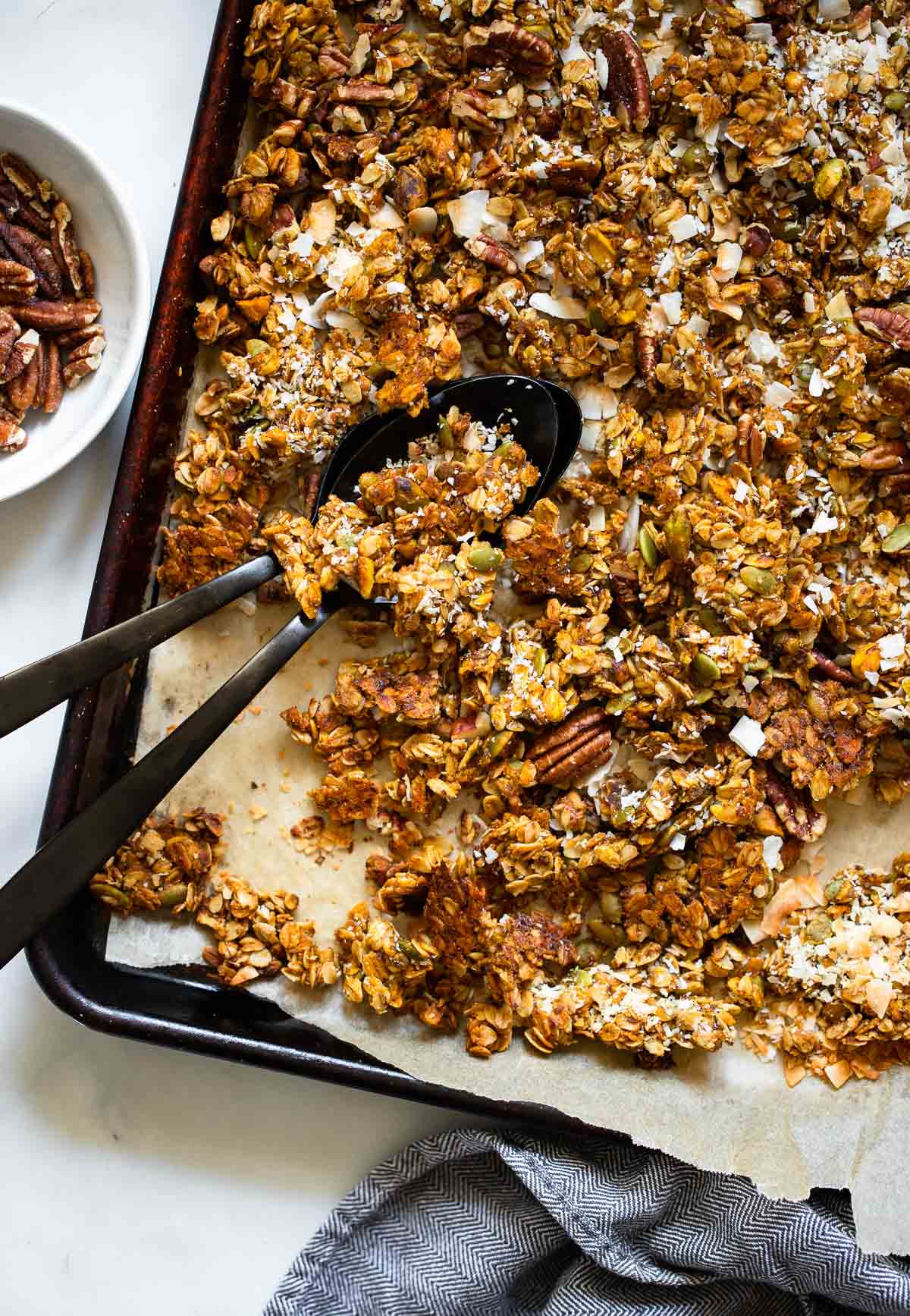 pumpkin granola in a pan with a serving spoon. 