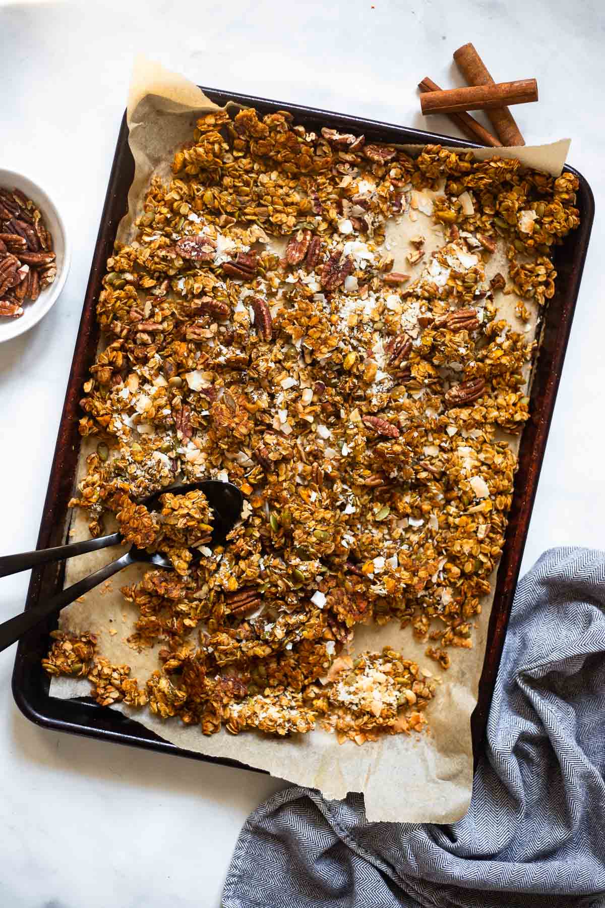pumpkin spice granola on pan with spoon.
