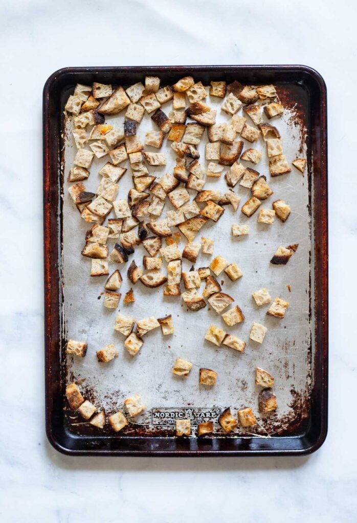 step 1 make the croutons by toasting bread in the oven on baking sheet.