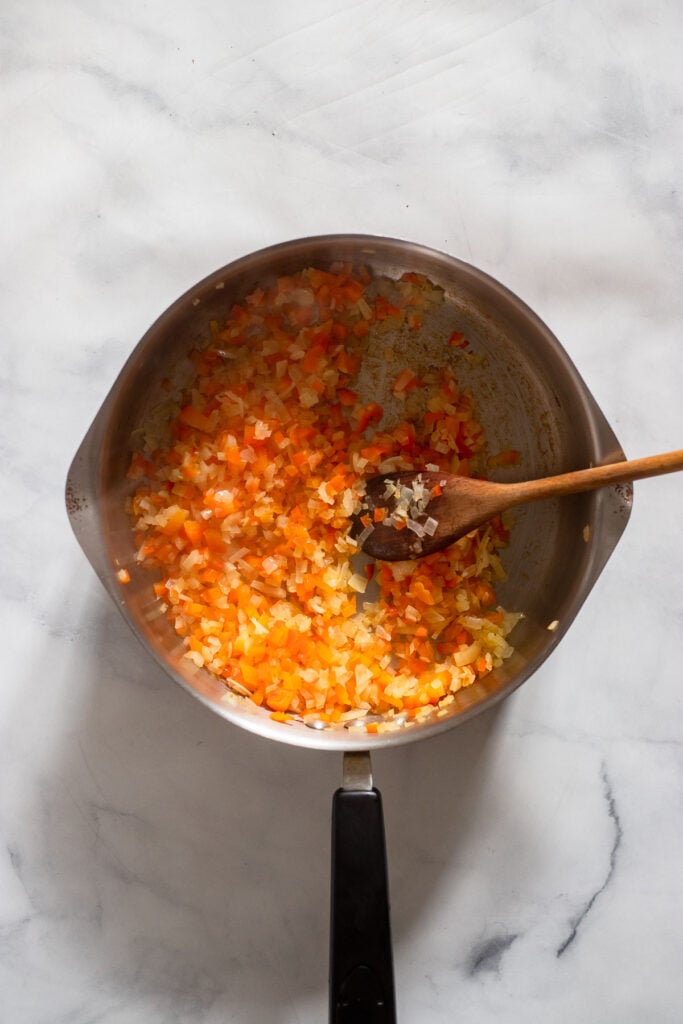 Add oil, onion, and pepper to pan and sauté.