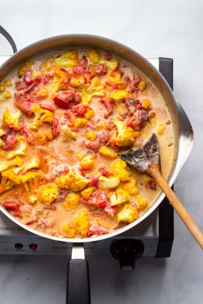 add coconut milk and tomatoes and bring to a simmer.