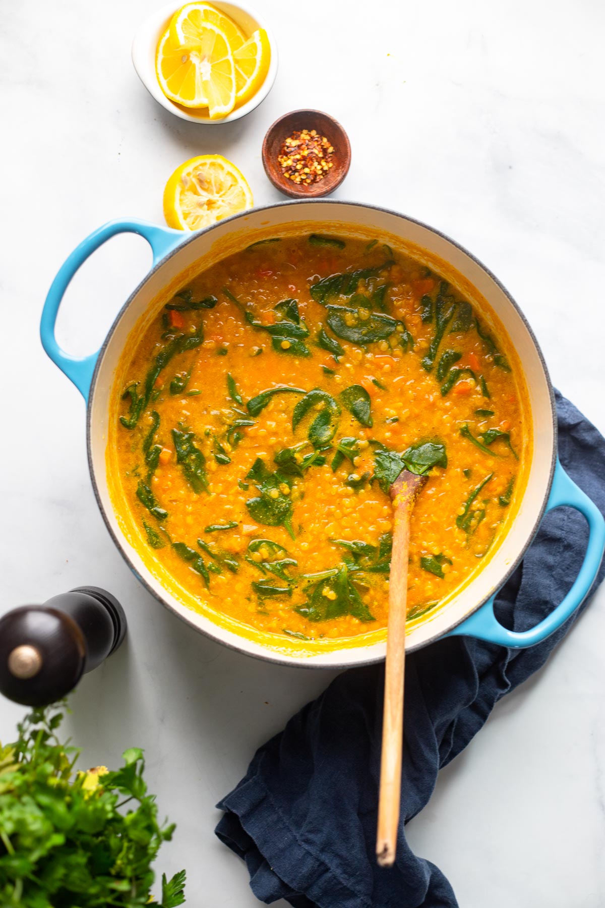 red lentil soup in blue dutch oven with wooden spoon.