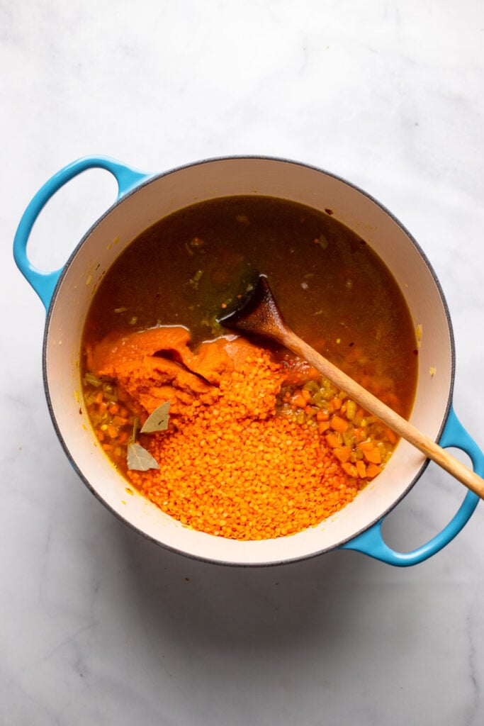 Add the red lentils pumpkin, broth, and bay leaf to your pot.