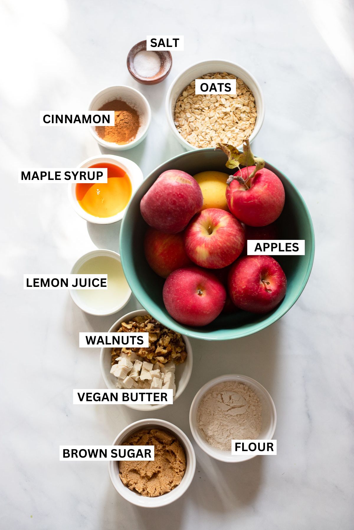 vegan apple crisp ingredients in small bowls with labels.