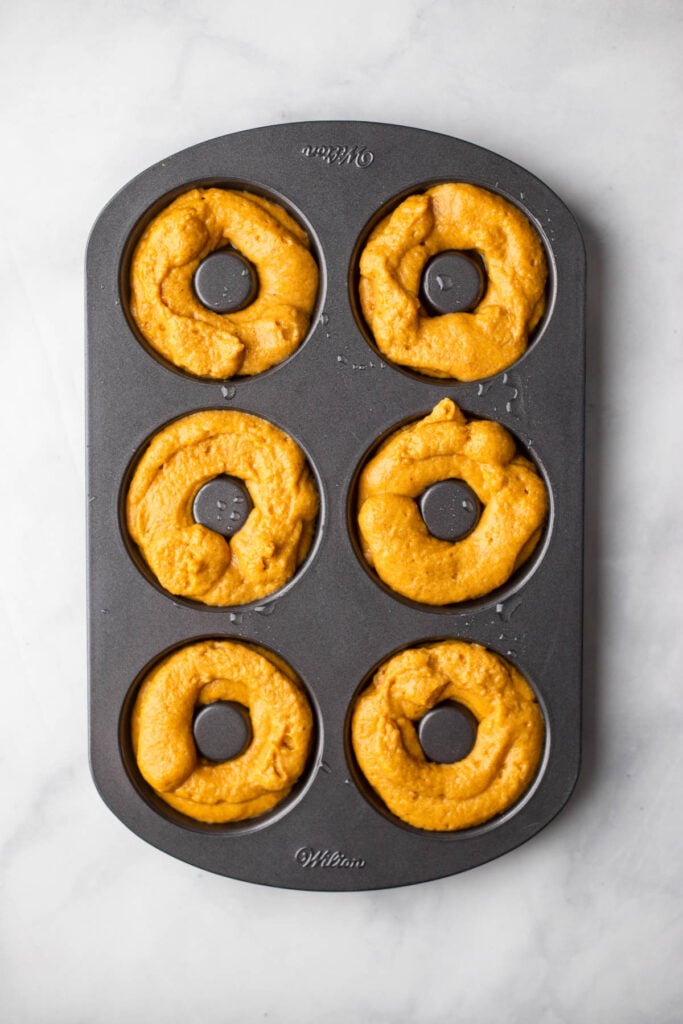 Pipe the donut batter into your donut pan.