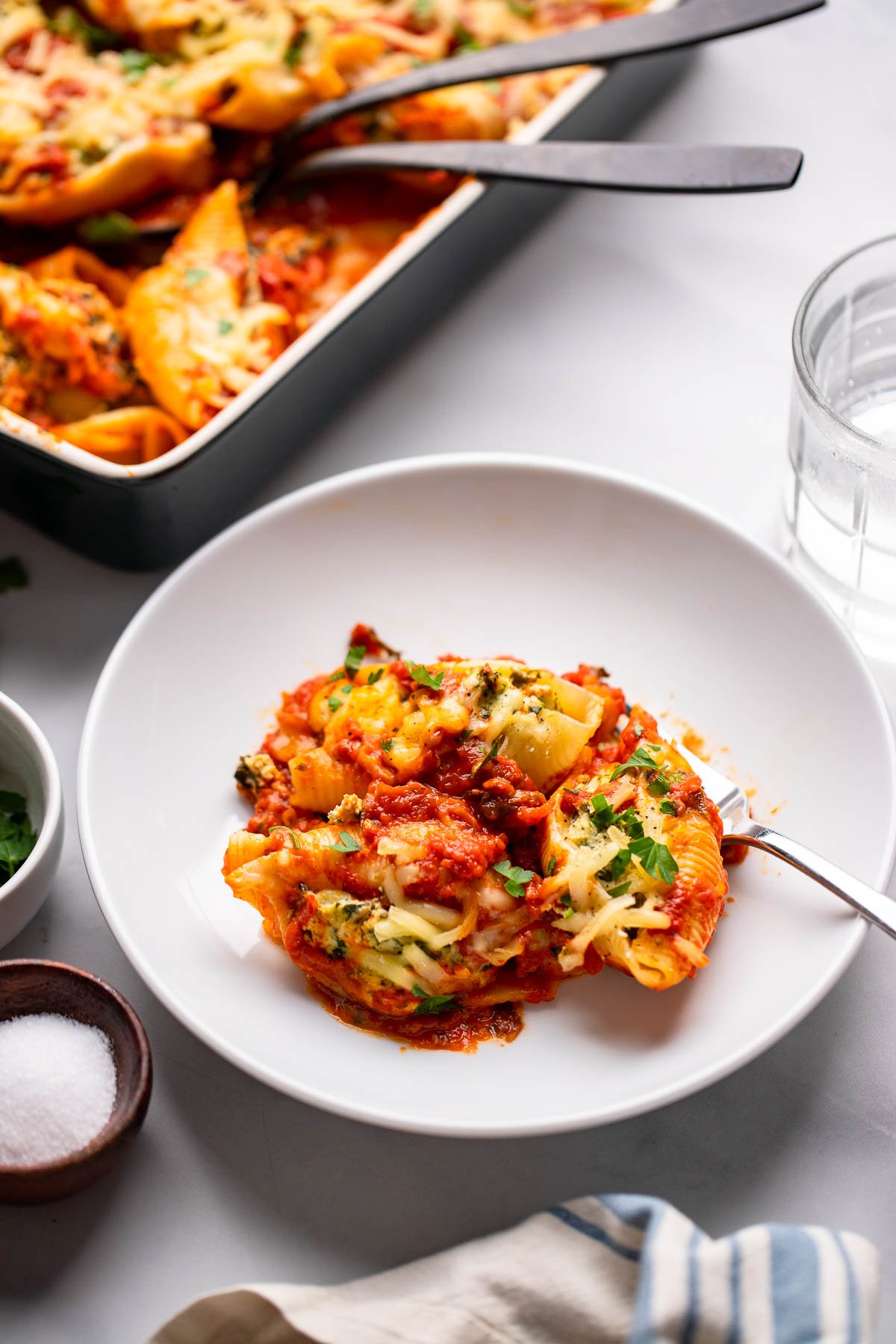 stuffed shells on a white plate with a fork.