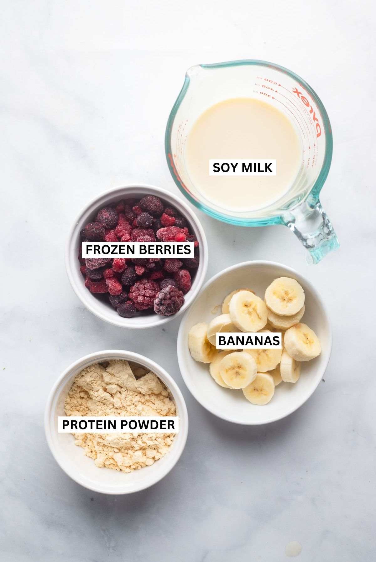 berry protein smoothie ingredients in bowls with labels.